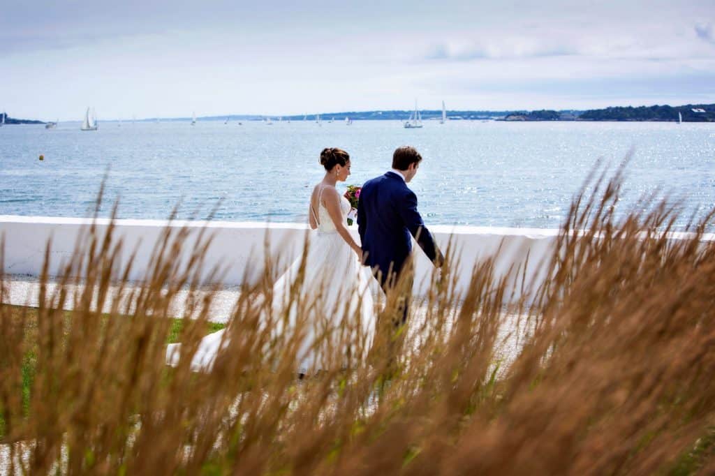 Bride and Groom Holding Hands by Waterside